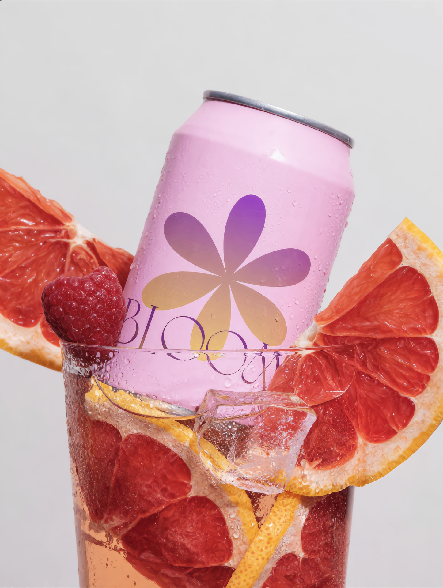Bloom pink can with grapefruit and raspberry in a glass