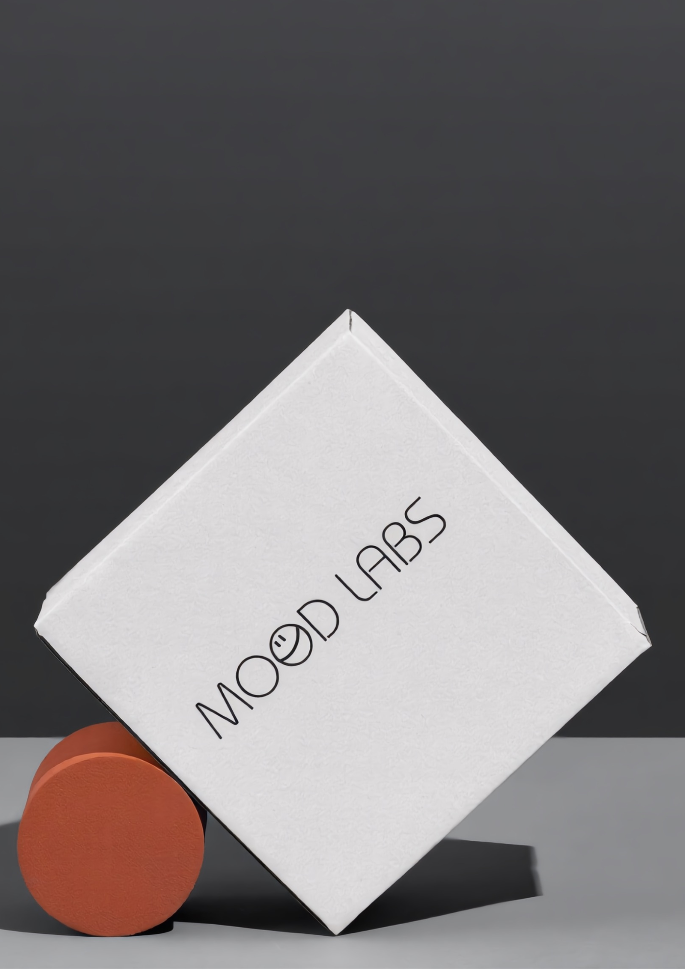 Mood Labs tilted paper box balanced on a terracotta puck